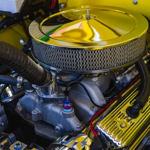 Engine components beneath the hood of a car