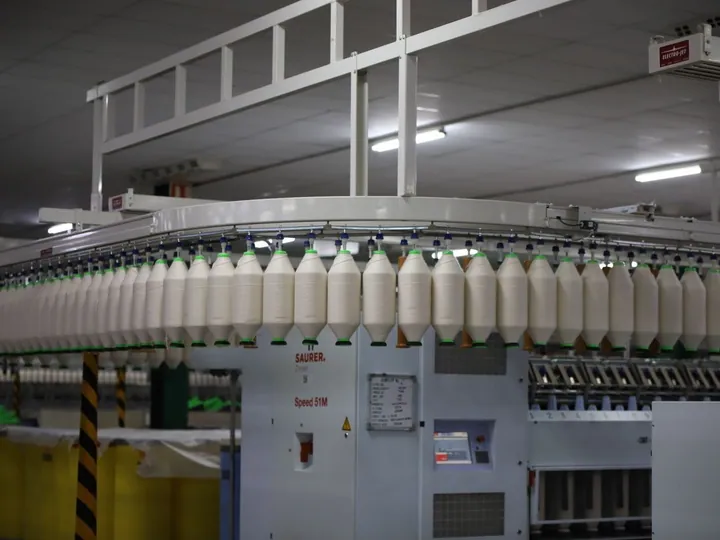 Rows of white yarn on textile production machinery